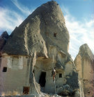 Cone dwelling with farmer climbing up to his pigeon loft on one pole ladder, Cappadocia, Turkey